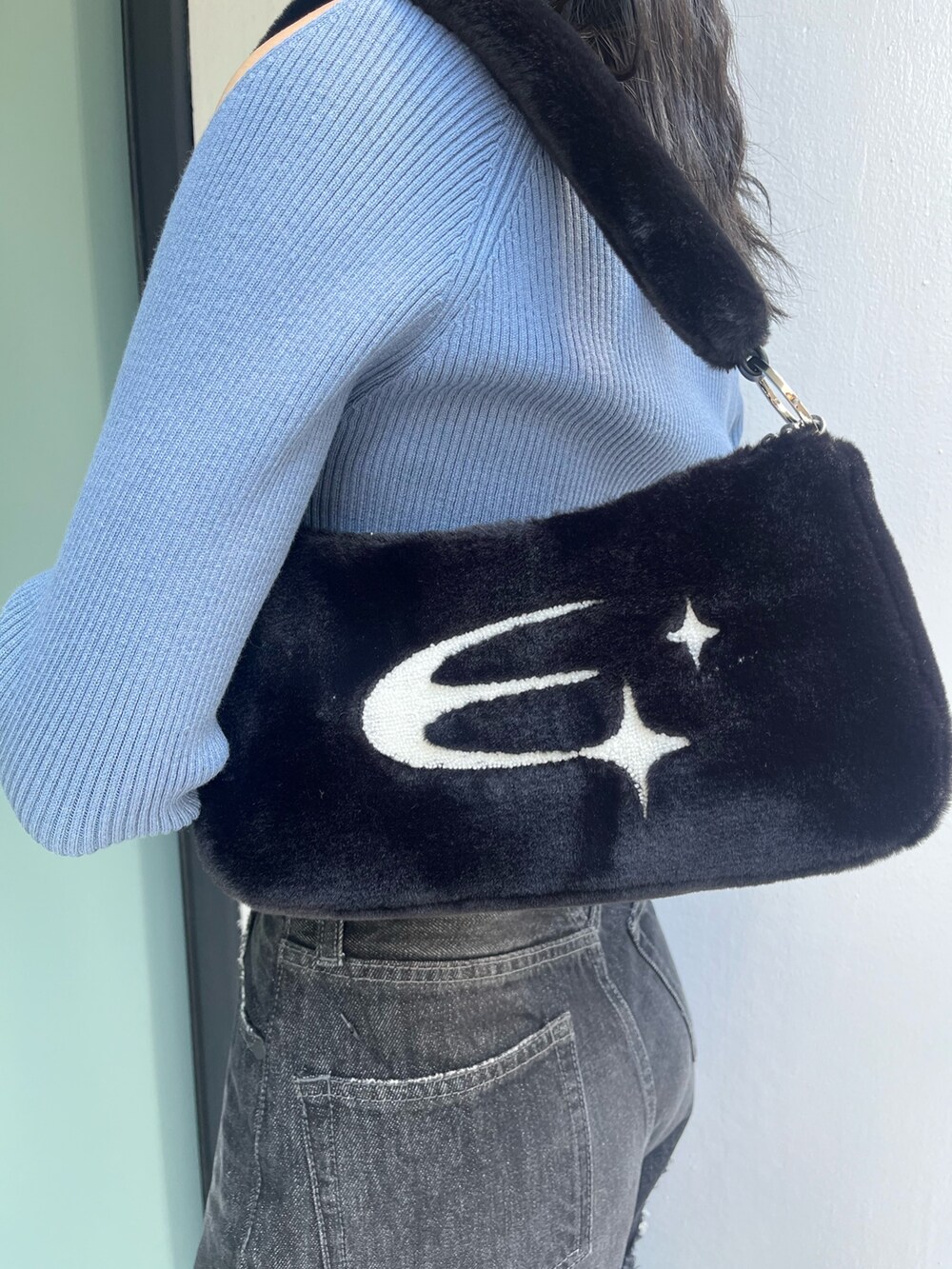 ブラック系のデニムパンツ、ブラック系のブーツ、ブルー系のニット/セーターを着用したレディースの秋コーディネートの7枚目の写真