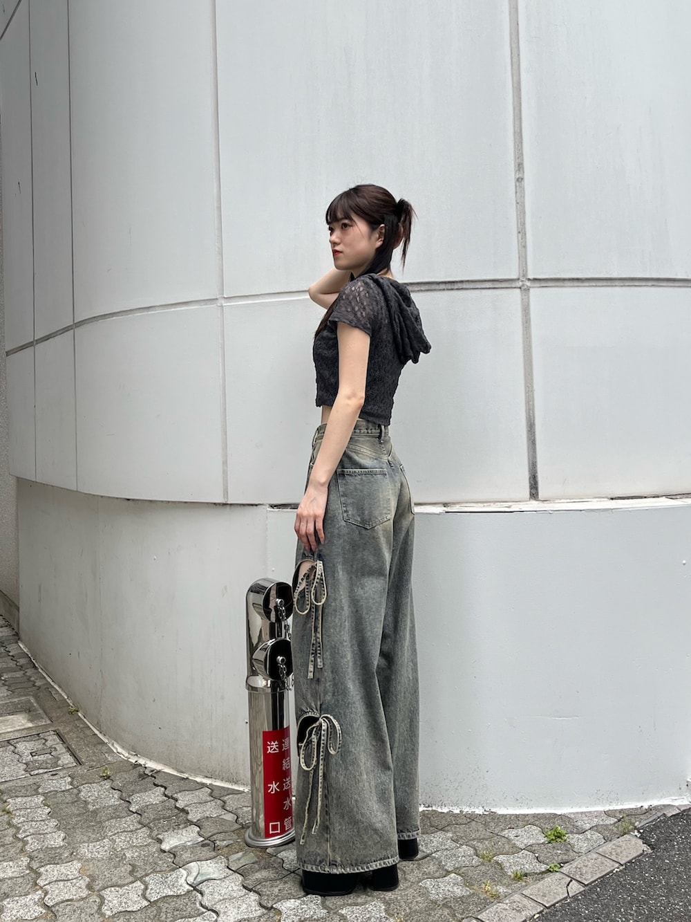 ブルー系のデニムパンツ、ブラック系のサンダル、グレー系のTシャツ/カットソーを着用したレディースの夏コーディネートの2枚目の写真