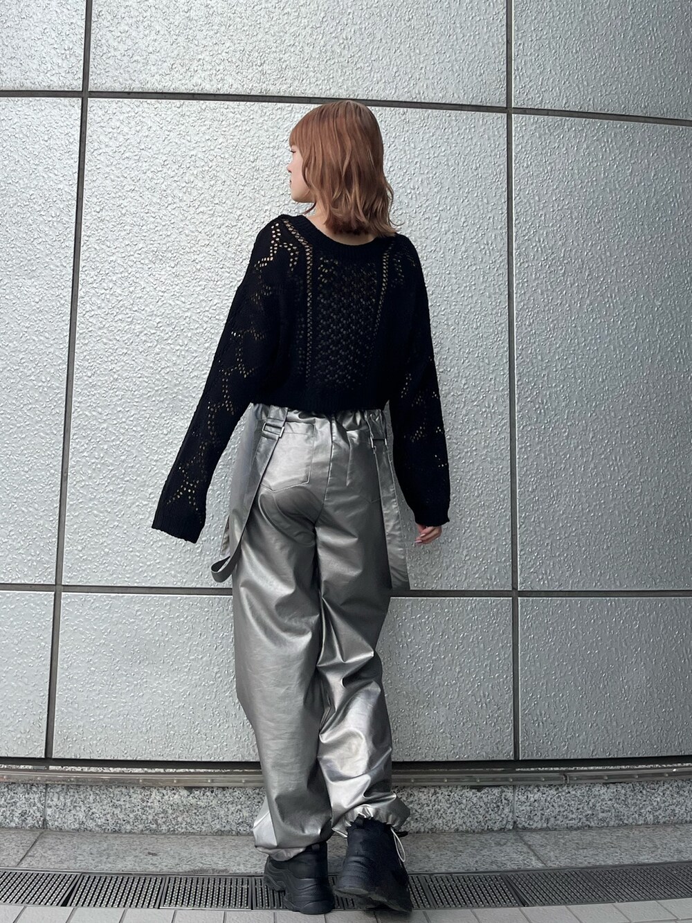 ブラック系のスニーカー、ブラック系のニット/セーター、ホワイト系のキャミソールを着用したレディースの冬コーディネートの3枚目の写真