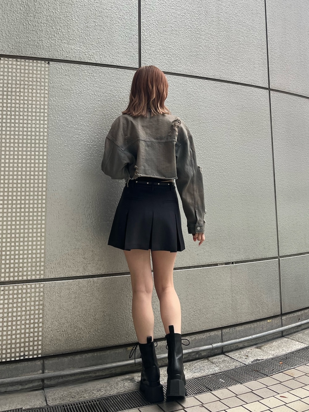 ブラック系のニット/セーター、グレー系のスカート、ブラック系のブーツを着用したレディースの冬コーディネートの3枚目の写真