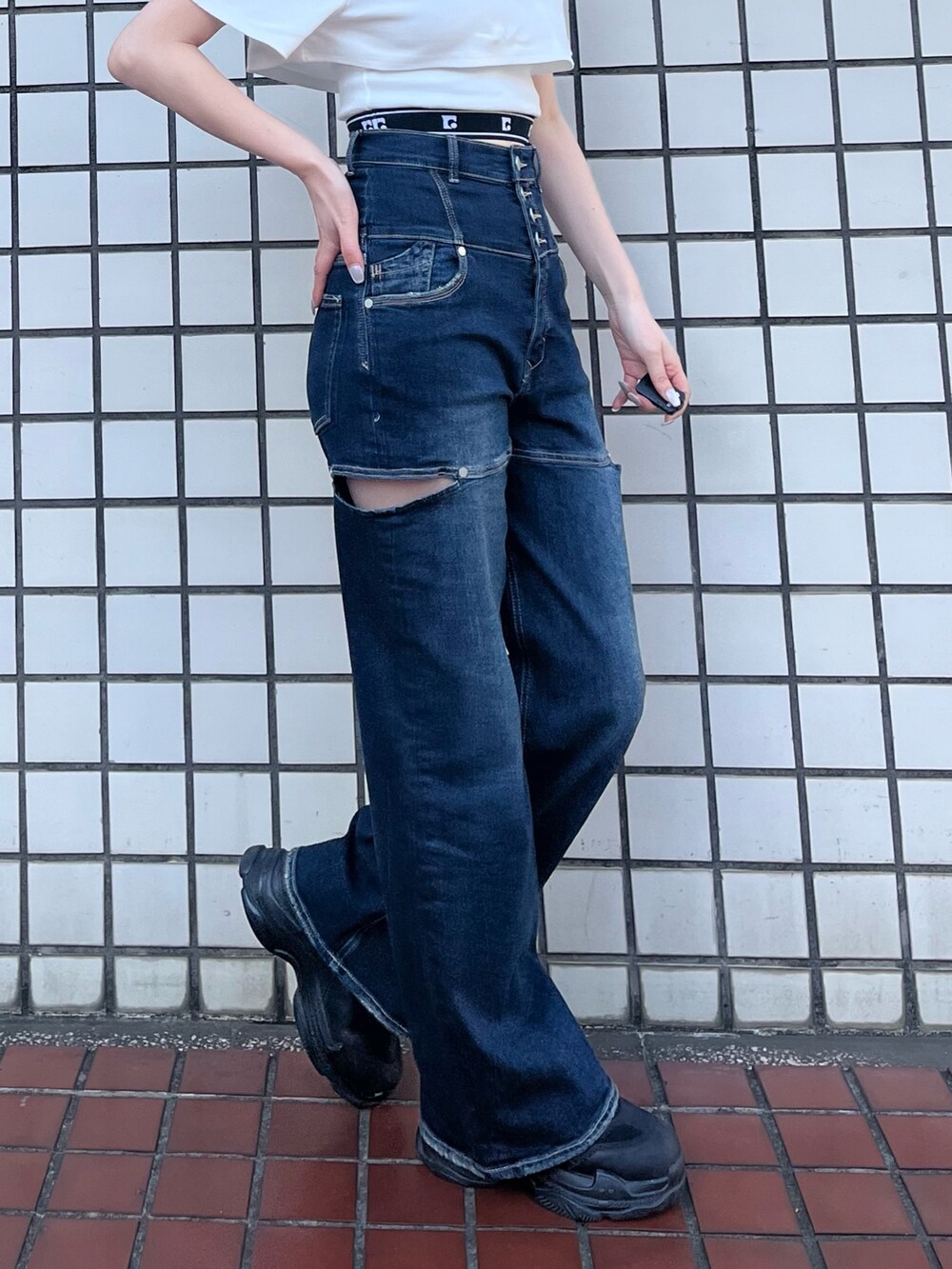 ブラック系のスニーカー、ブルー系のデニムパンツ、ホワイト系のTシャツ/カットソーを着用したレディースの春コーディネートの5枚目の写真