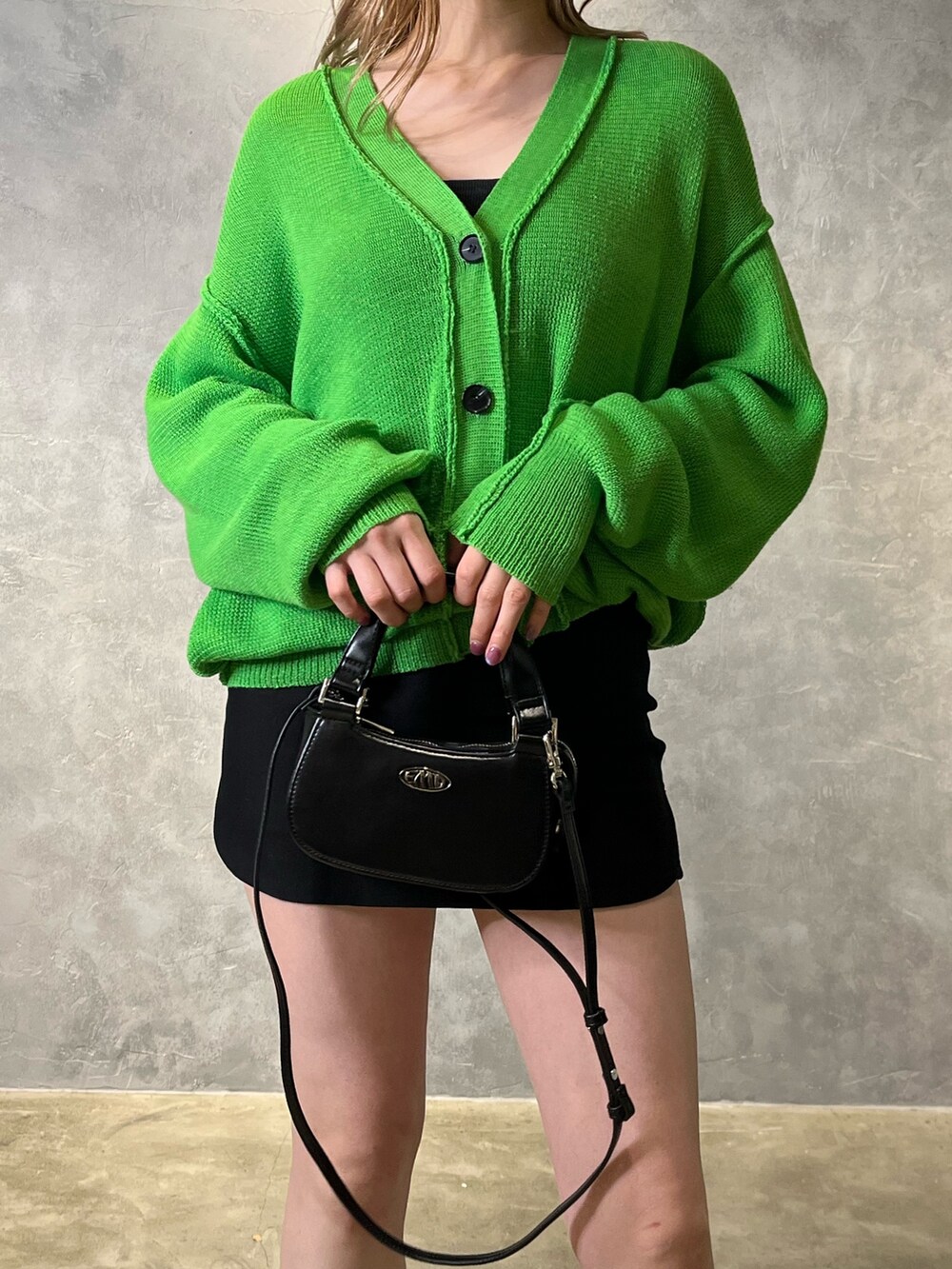 グリーン系のカーディガン/ボレロ、ブラック系のブーツ、ブラック系のスカートを着用したレディースの冬コーディネートの5枚目の写真