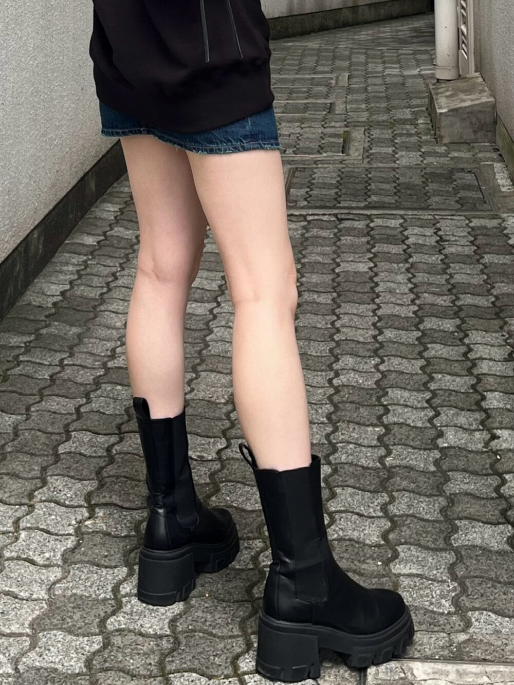 ブラック系のブーツ、ブラック系のショルダーバッグ、ブラック系のスウェットを着用したレディースの夏コーディネートの7枚目の写真