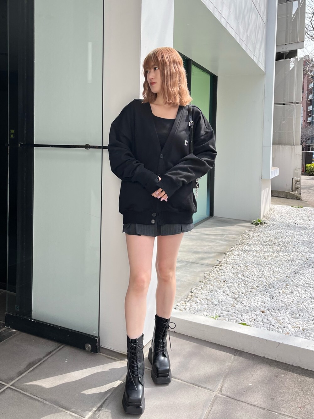 ブラック系のブーツ、ブラック系のキャミソール、ブラック系のカーディガン/ボレロを着用したレディースの春コーディネートの2枚目の写真
