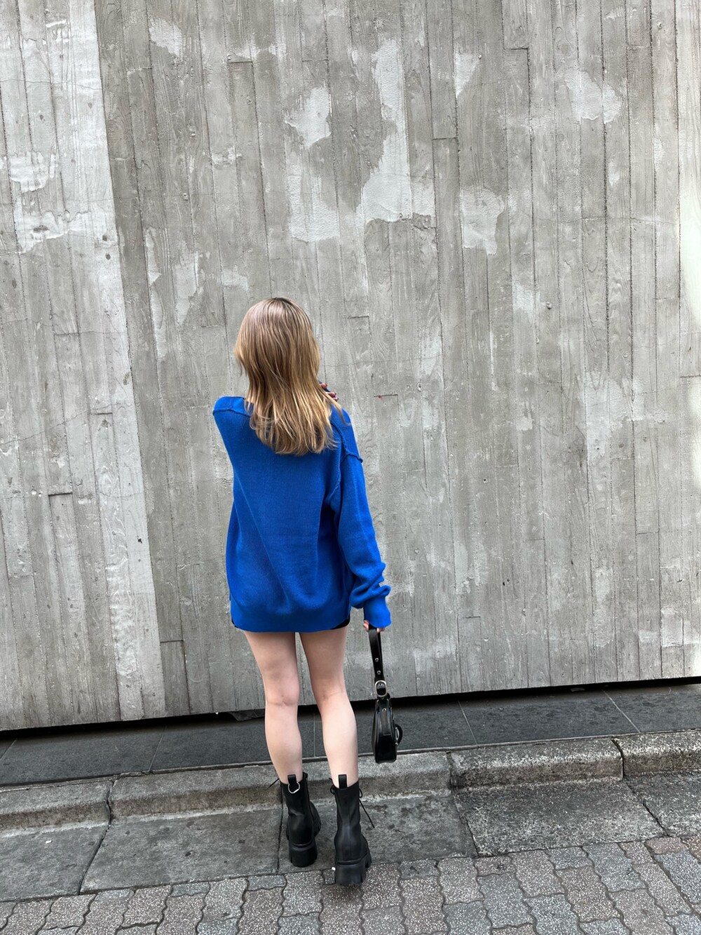 ブラック系のハンドバッグ、ブラック系のブーツ、ホワイト系のキャミソールを着用したレディースの春コーディネートの4枚目の写真