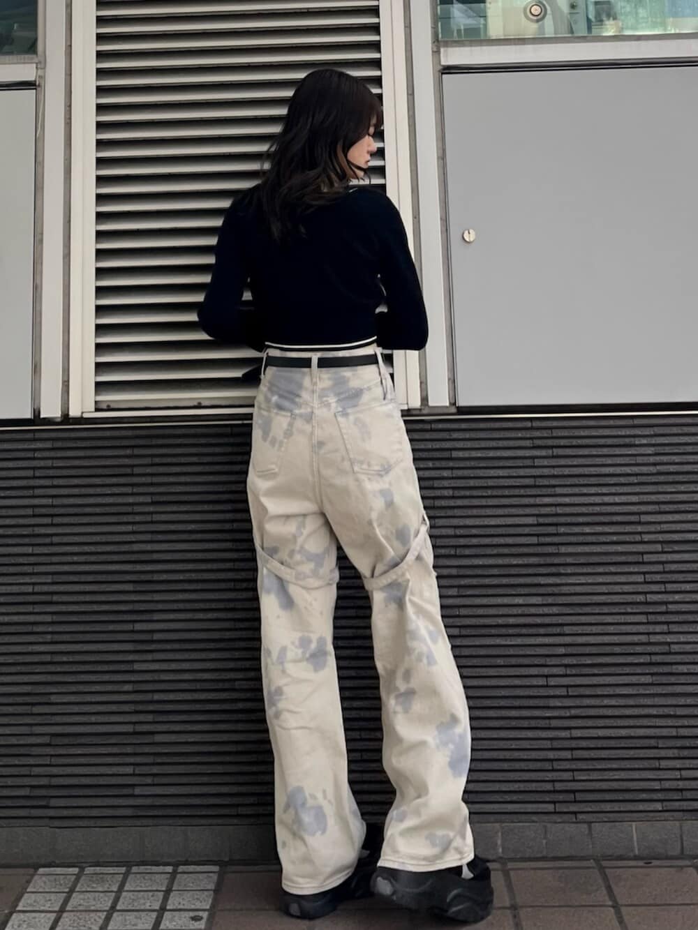 ブラック系のスニーカー、ホワイト系のデニムパンツ、ブラック系のニット/セーターを着用したレディースの冬コーディネートの4枚目の写真