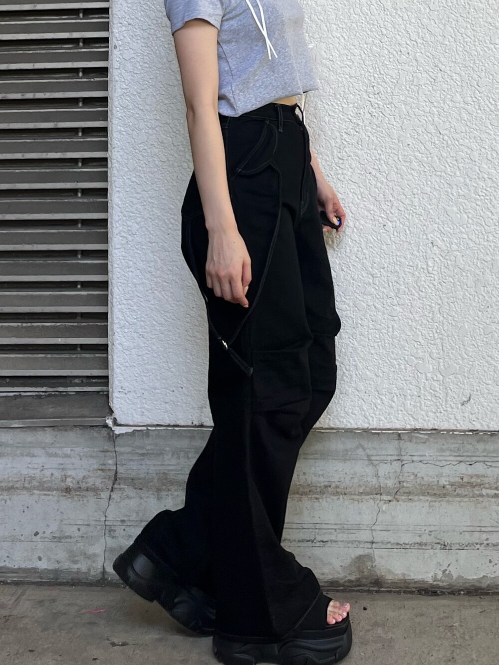 ブラック系のデニムパンツ、グレー系のTシャツ/カットソー、ブラック系のサンダルを着用したレディースの夏コーディネートの5枚目の写真