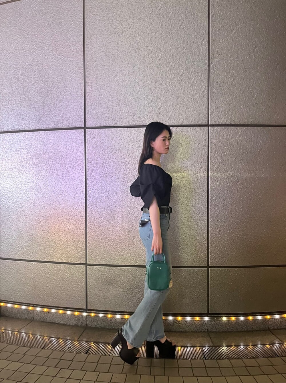 ブルー系のショルダーバッグ、ブラック系のサンダル、ブルー系のデニムパンツを着用したレディースの春コーディネートの3枚目の写真
