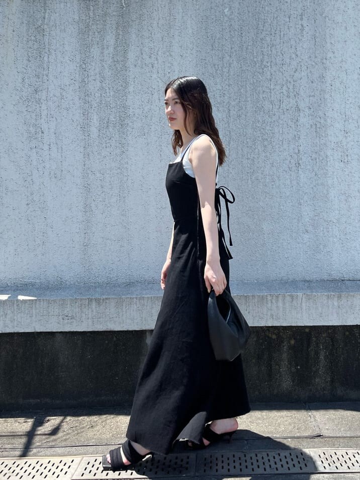 ブラック系のワンピース、ホワイト系のタンクトップ、ブラック系のサンダルを着用したレディースの夏コーディネートの5枚目の写真