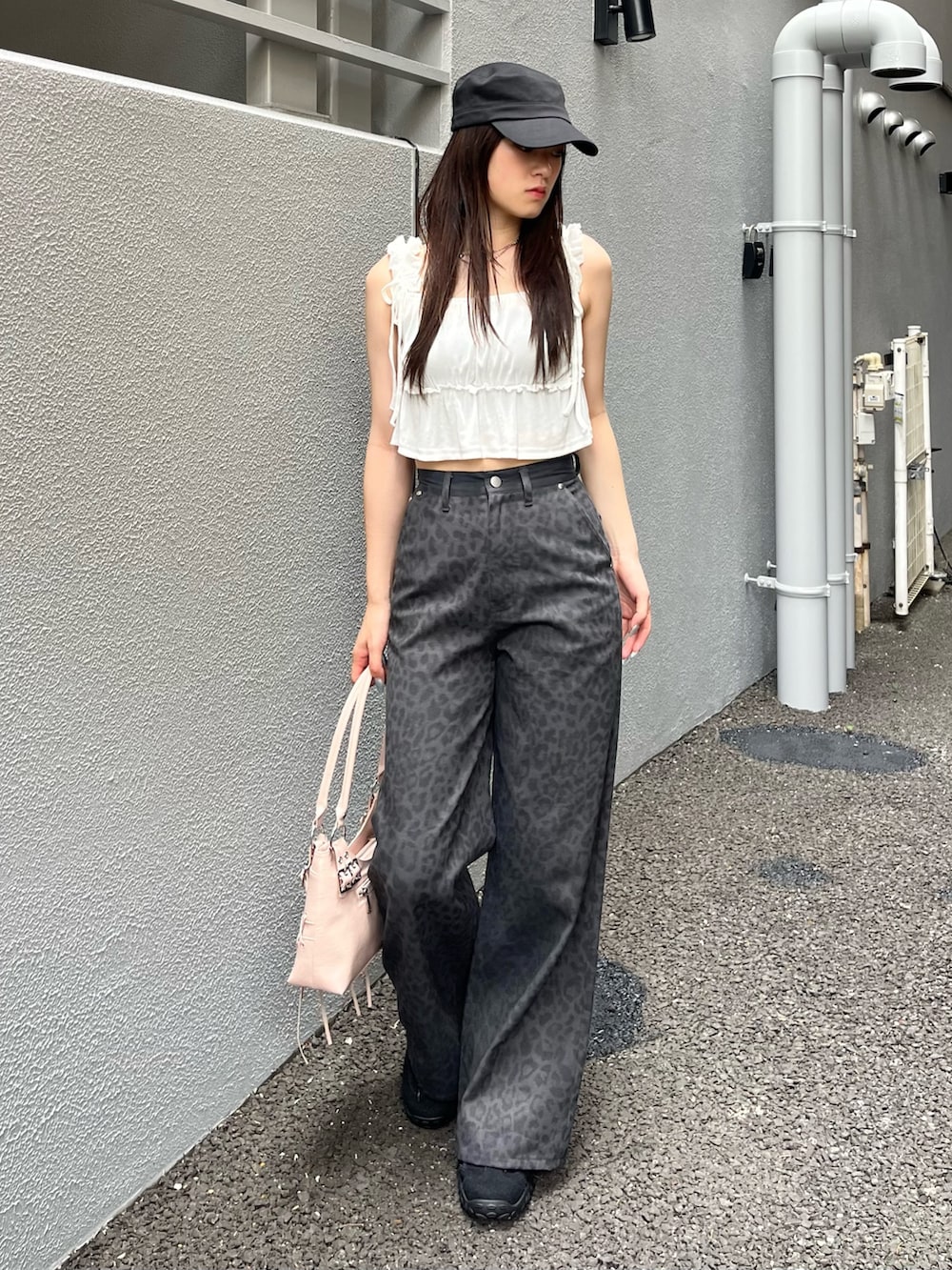 ピンク系のショルダーバッグ、グレー系のその他パンツ、ブラック系のスニーカーを着用したレディースの夏コーディネートの2枚目の写真
