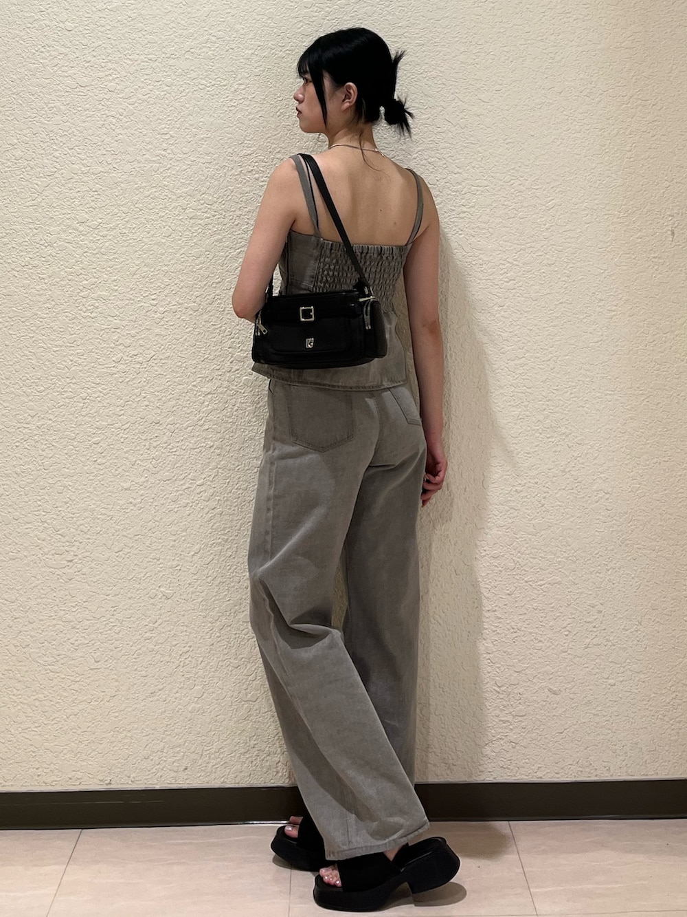 グレー系のデニムパンツ、グレー系のキャミソール、ブラック系のサンダルを着用したレディースの夏コーディネートの3枚目の写真