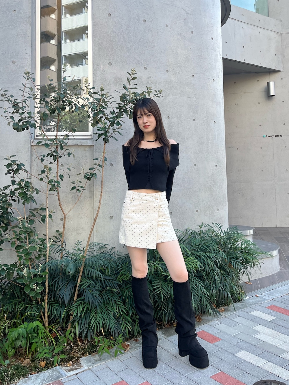 ホワイト系のスカート、ブラック系のブーツ、ブラック系のニット/セーターを着用したレディースの秋コーディネートの2枚目の写真