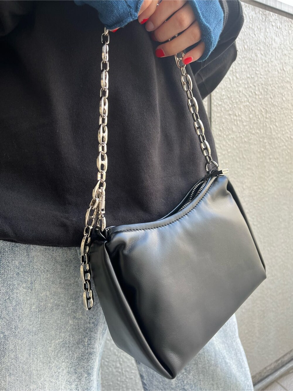 その他のパンプス、ブルー系のデニムパンツ、ブラック系のスウェットを着用したレディースの秋コーディネートの9枚目の写真