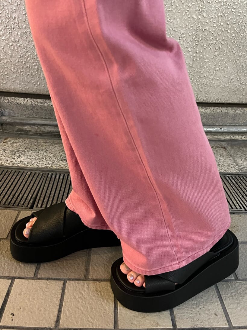 ピンク系のデニムパンツ、ブラック系のサンダル、ブラック系のハンドバッグを着用したレディースの夏コーディネートの7枚目の写真