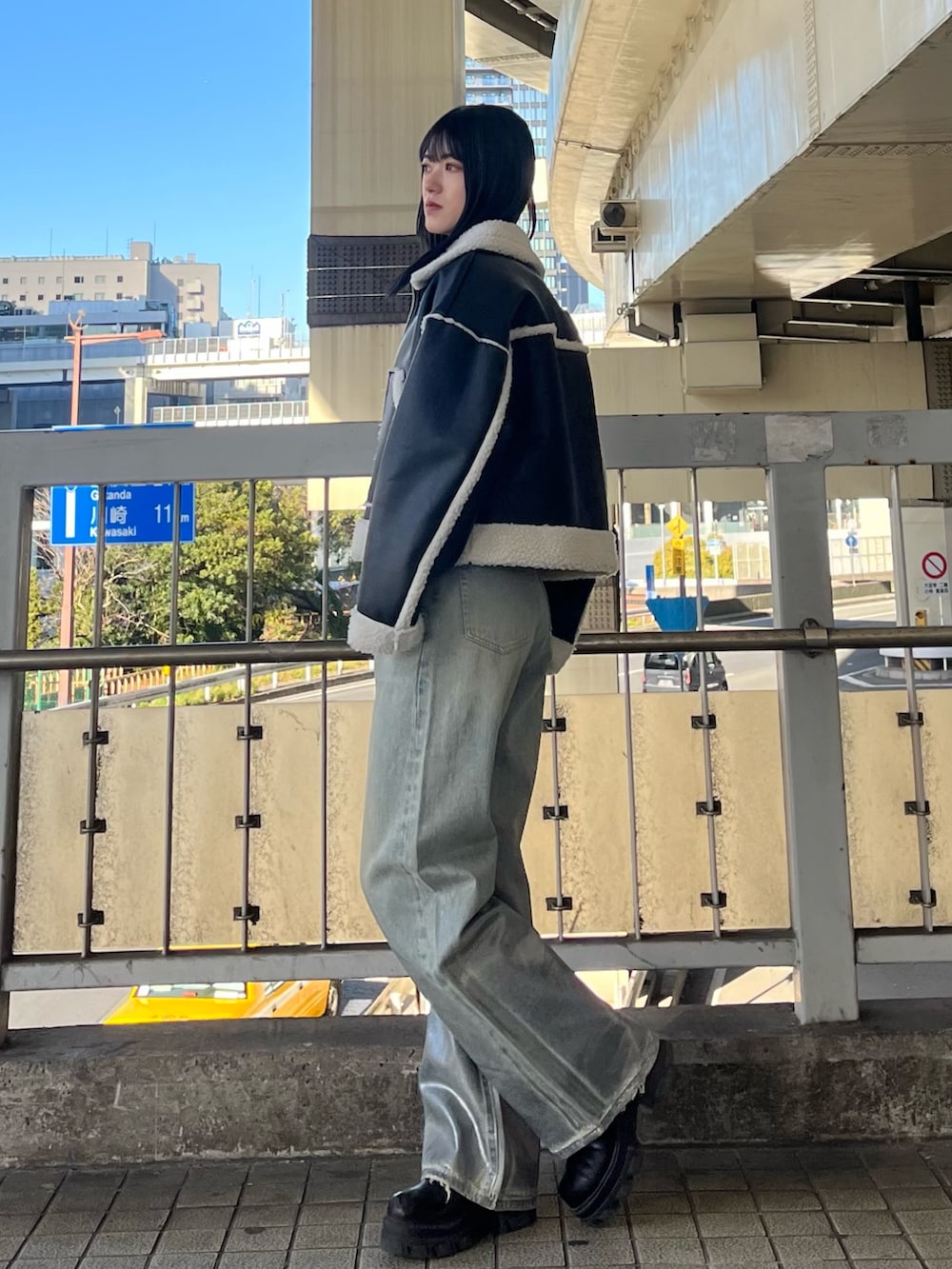 ブルー系のデニムパンツ、ブラック系のニット/セーター、ブラック系のブーツを着用したレディースの冬コーディネートの2枚目の写真