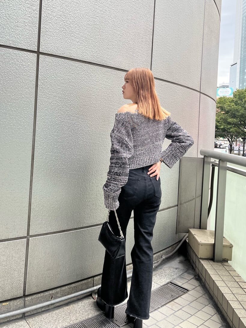 ブラック系のブーツ、ブラック系のデニムパンツ、その他のニット/セーターを着用したレディースの秋コーディネートの3枚目の写真