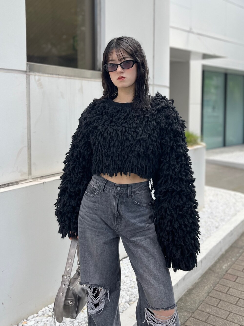 ブラック系のブーツ、グレー系のデニムパンツ、ブラック系のニット/セーターを着用したレディースの秋コーディネートの5枚目の写真