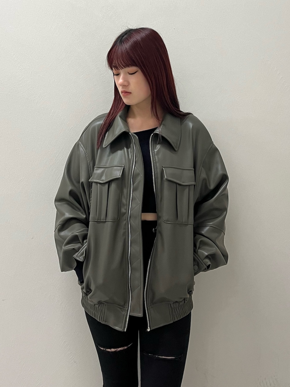 グレー系のブルゾン、ブラック系のデニムパンツ、ブラック系のニット/セーターを着用したレディースの冬コーディネートの5枚目の写真