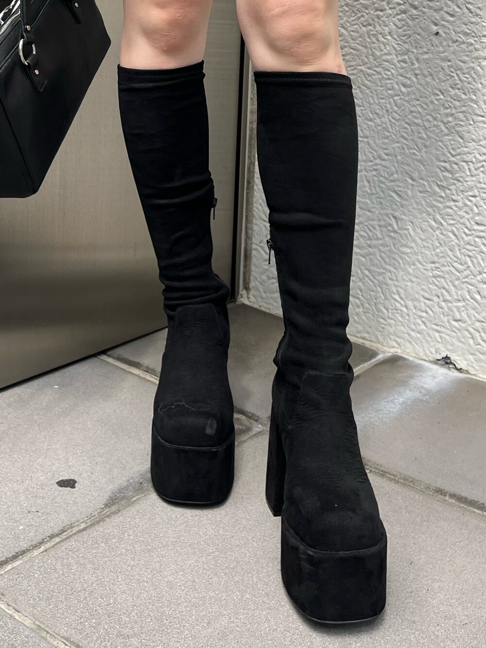 ブラック系のショルダーバッグ、ブラック系のスカート、その他のブーツを着用したレディースの秋コーディネートの6枚目の写真