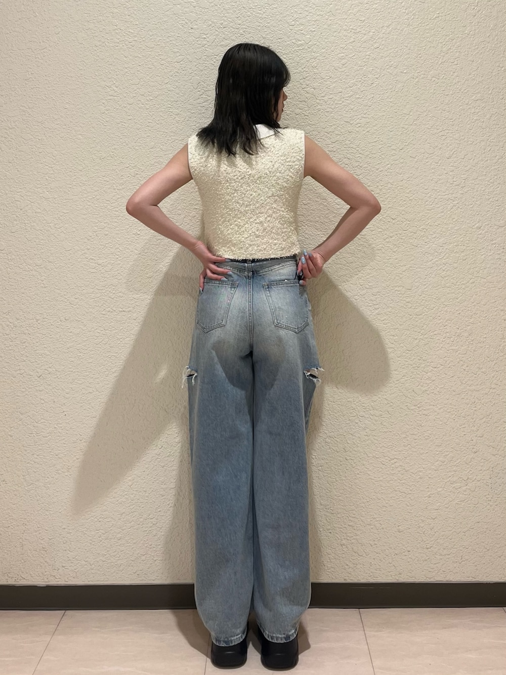 ブルー系のデニムパンツ、ブラック系のサンダル、ホワイト系のタンクトップを着用したレディースの夏コーディネートの4枚目の写真