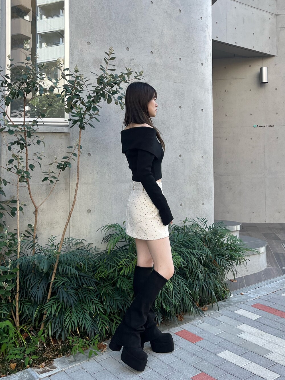 ホワイト系のスカート、ブラック系のブーツ、ブラック系のニット/セーターを着用したレディースの秋コーディネートの3枚目の写真