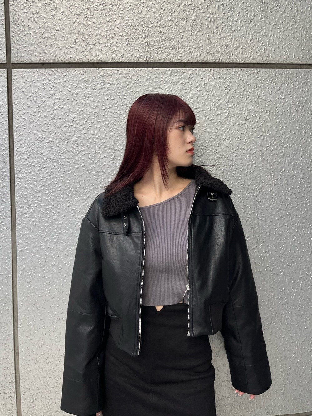 ブラック系のスカート、ブラック系のブルゾン、グレー系のニット/セーターを着用したレディースの冬コーディネートの6枚目の写真