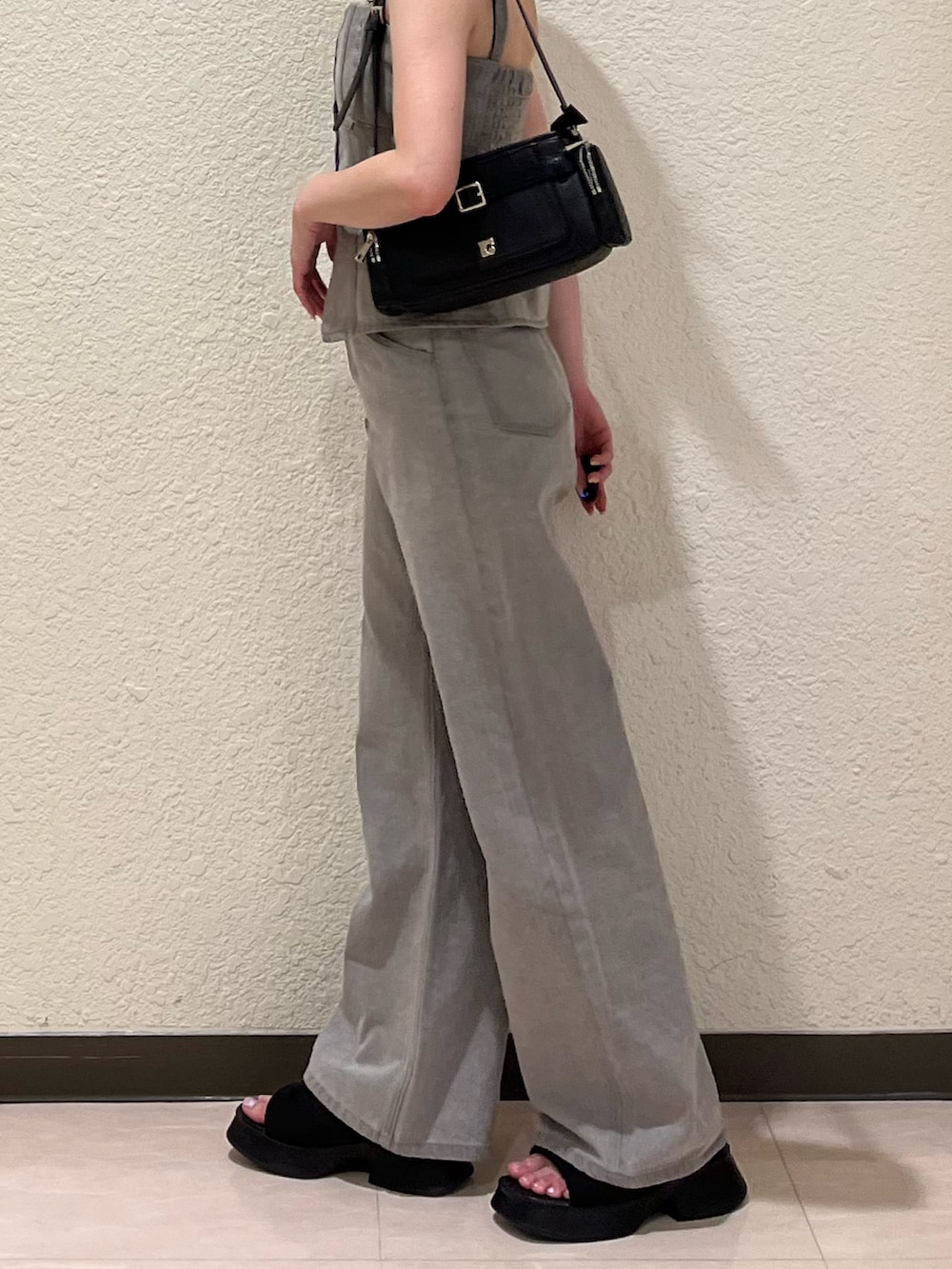 グレー系のデニムパンツ、グレー系のキャミソール、ブラック系のサンダルを着用したレディースの夏コーディネートの7枚目の写真