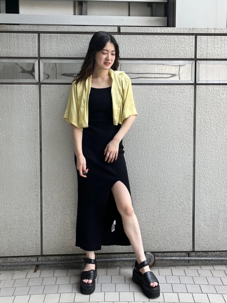 ブラック系のサンダル、ブラック系のワンピース、イエロー系のシャツ/ブラウスを着用したレディースの夏コーディネートの2枚目の写真