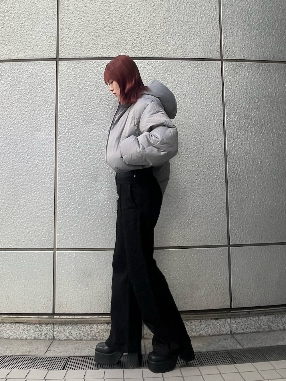 ブラック系のデニムパンツ、ブルー系のニット/セーター、グレー系のダウンジャケット/コートを着用したレディースの冬コーディネートの2枚目の写真