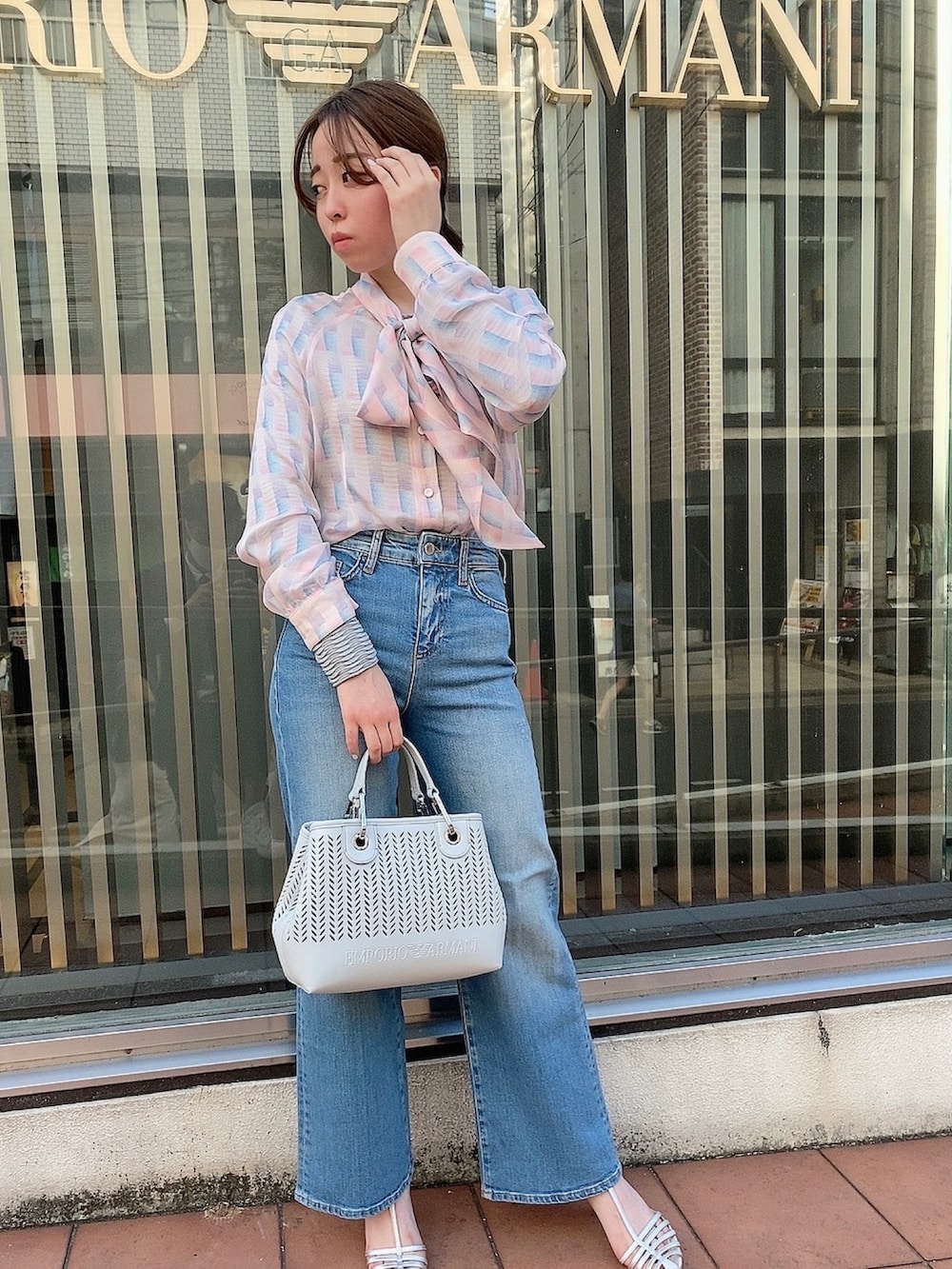 ピンク系のシャツ/ブラウス、ブルー系のデニムパンツ、ホワイト系のショルダーバッグを着用したレディースの夏コーディネートの2枚目の写真