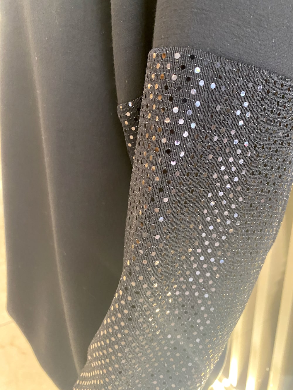 ブラック系のスウェット、ホワイト系のスニーカー、ブラック系のレギンス/スパッツを着用したレディースの春コーディネートの2枚目の写真