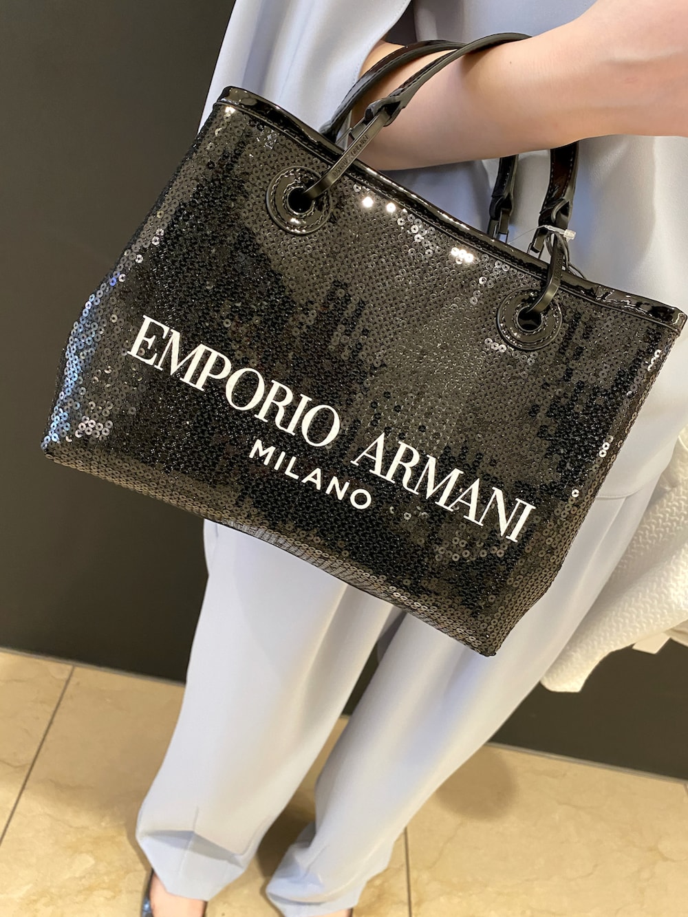 ホワイト系のジャケット/アウター、ブラック系のシューズ、ブラック系のハンドバッグを着用したレディースの冬コーディネートの3枚目の写真