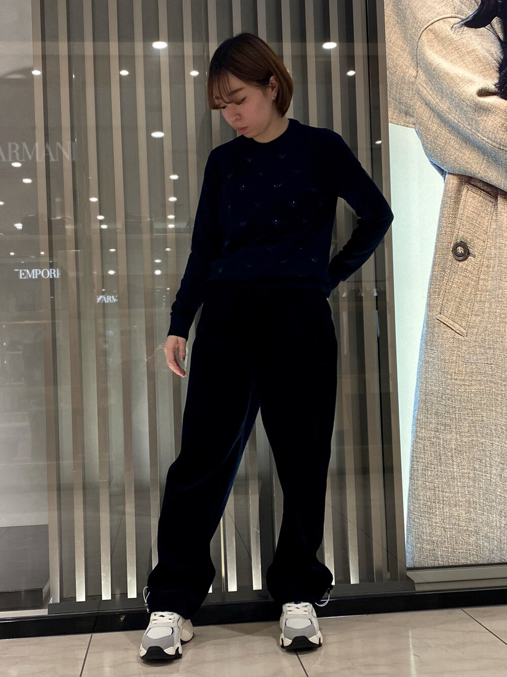 ベージュ系のジャケット/アウター、ブルー系のニット/セーター、ブルー系のパンツを着用したレディースの秋コーディネートの3枚目の写真