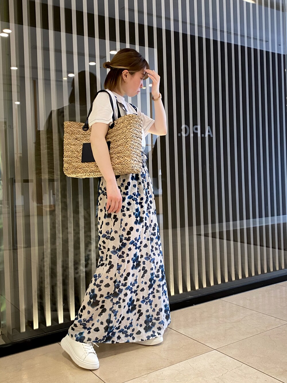 ホワイト系のシャツ/ブラウス、ホワイト系のスカート、ブルー系のショルダーバッグを着用したレディースの春コーディネートの2枚目の写真