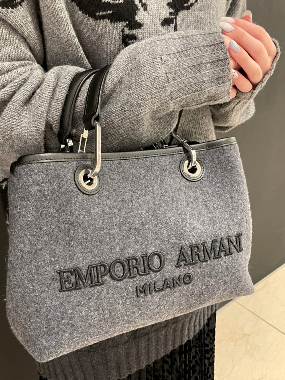 グレー系のニット/セーター、ブラック系のドレス、グレー系のショルダーバッグを着用したレディースの秋コーディネートの4枚目の写真