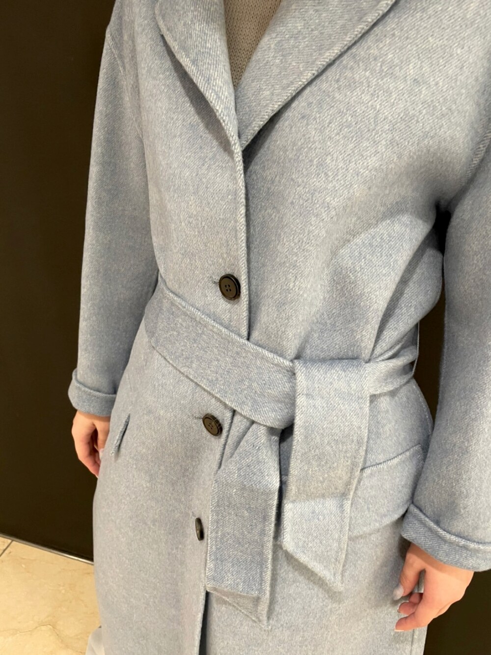 ブルー系のジャケット/アウター、ベージュ系のニット/セーター、グレー系のパンツを着用したレディースの秋コーディネートの4枚目の写真