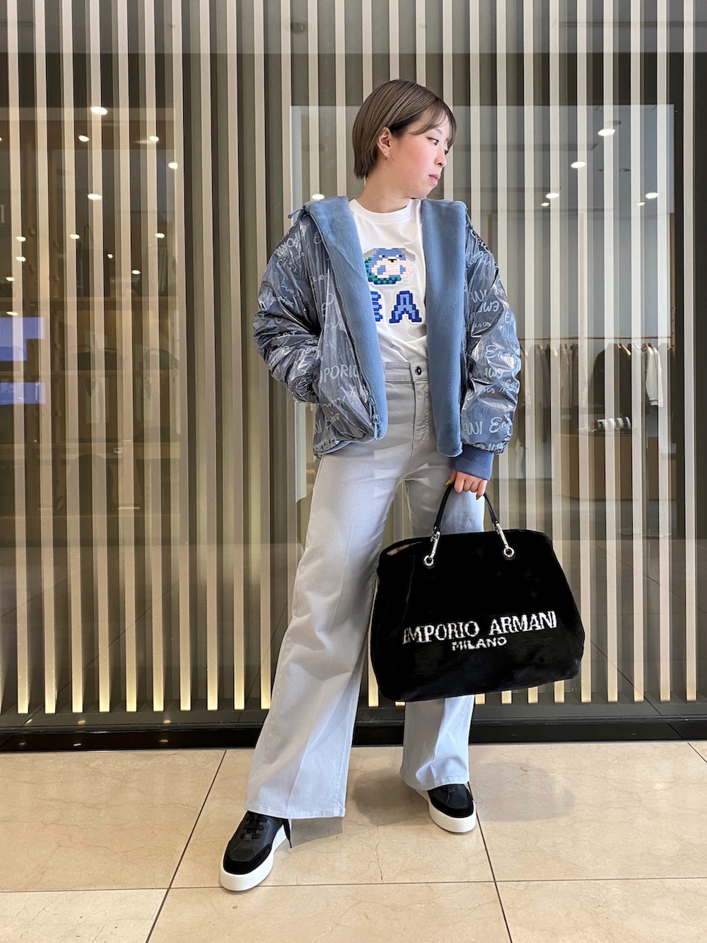 ブルー系のジャケット/アウター、ブラック系のハンドバッグ、ブルー系のデニムパンツを着用したレディースの秋コーディネートの2枚目の写真