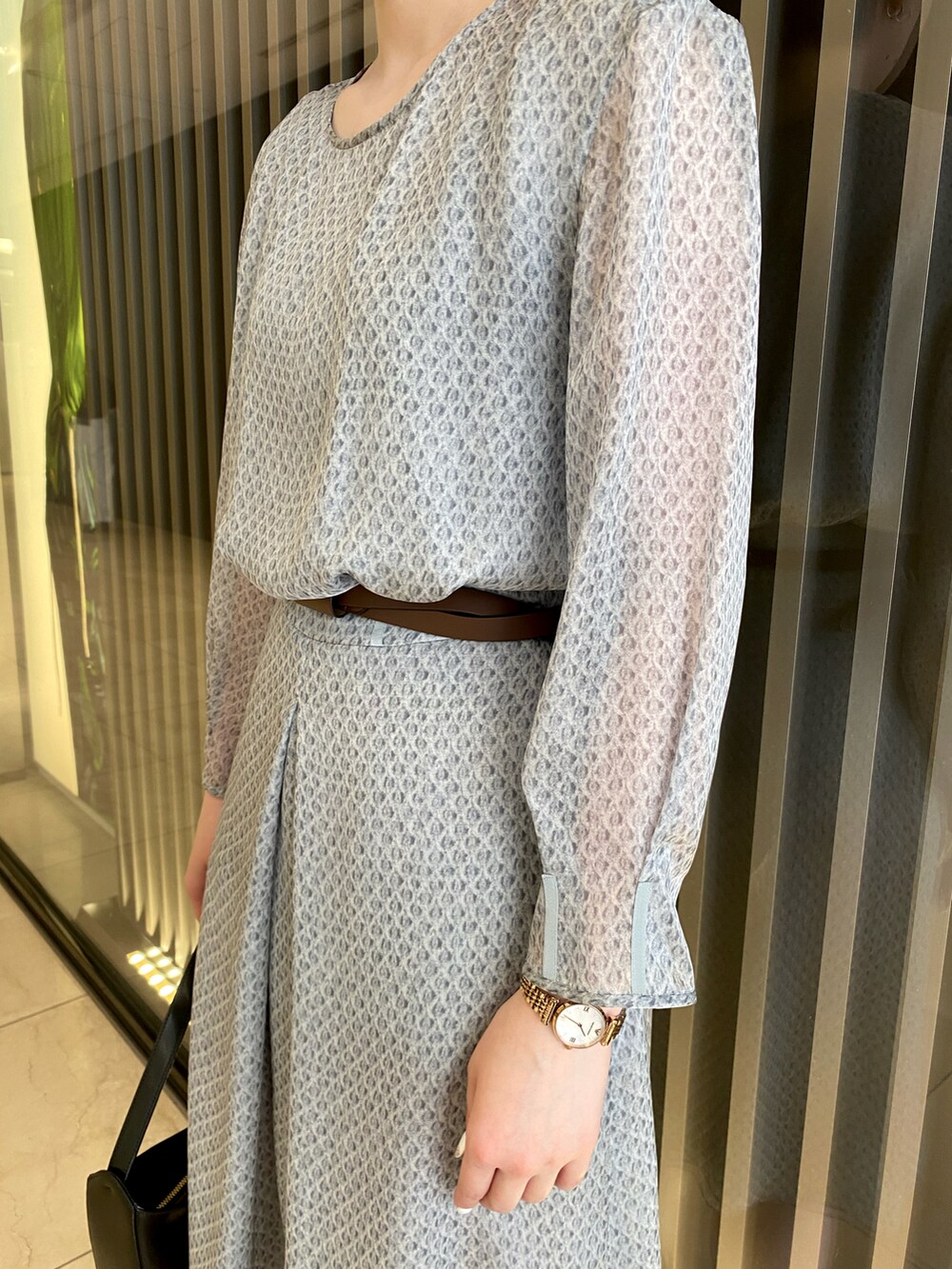 ブラック系のシューズ、ブラック系のバッグ、グレー系のワンピース/ドレスを着用したレディースの夏コーディネートの2枚目の写真