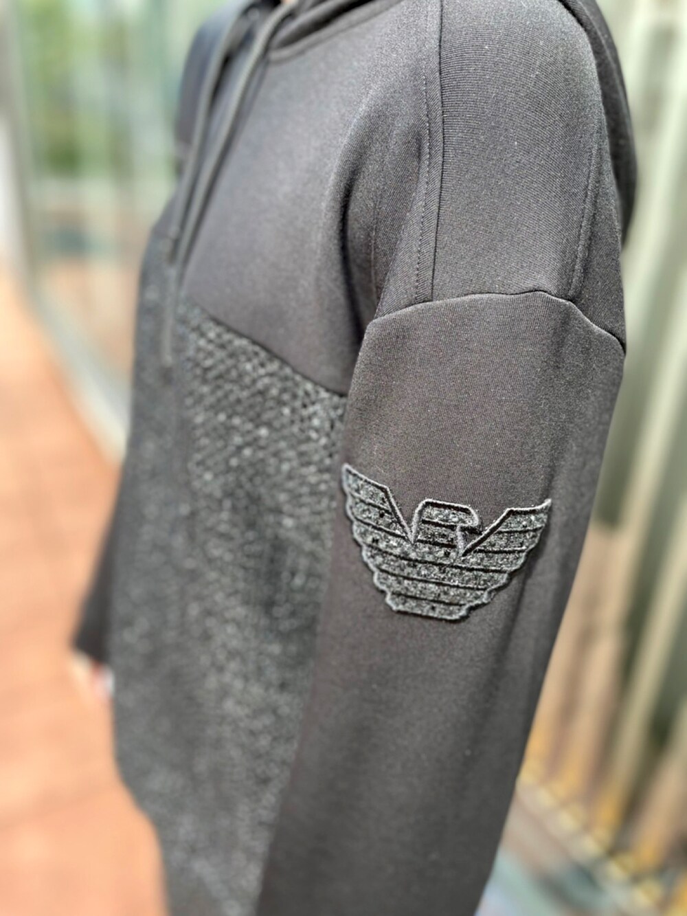 ブラック系のパーカー、ブラック系のスカート、ブラック系のスニーカーを着用したレディースの夏コーディネートの2枚目の写真