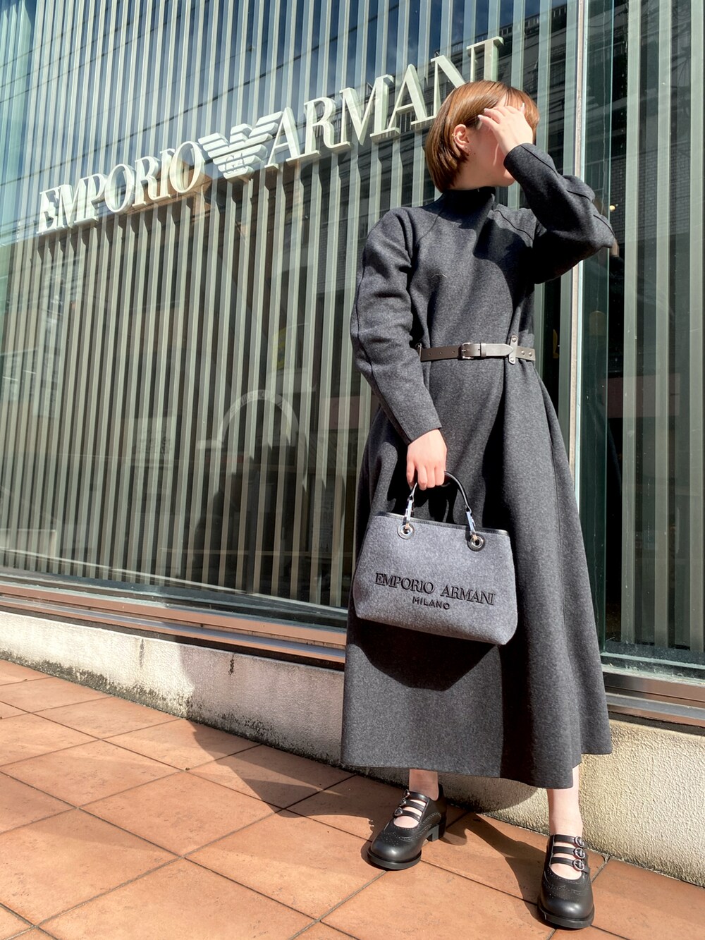 グレー系のワンピース、ベージュ系のカーディガン/ボレロ、グレー系のショルダーバッグを着用したレディースの秋コーディネートの2枚目の写真