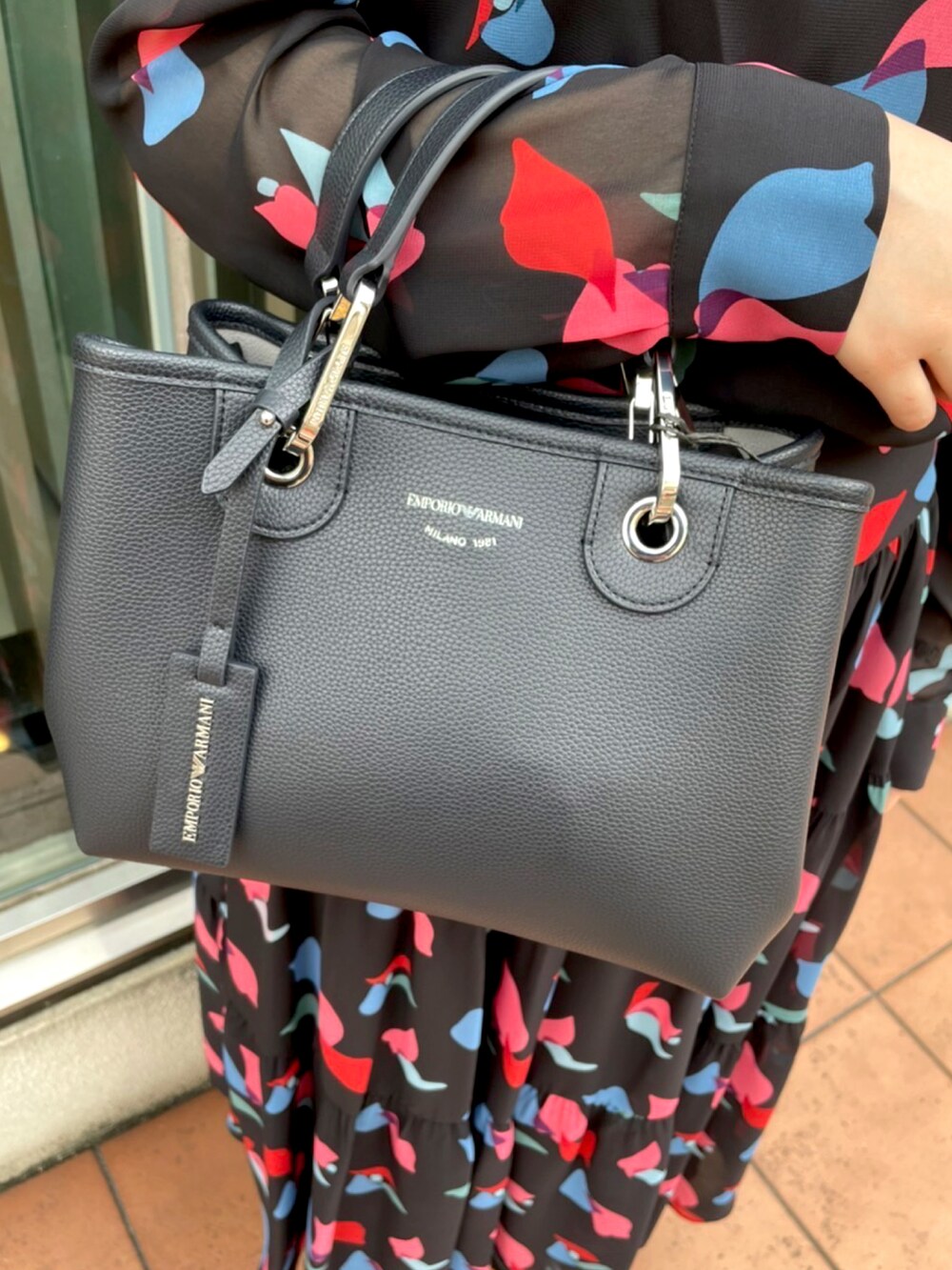 ブラック系のワンピース、ブラック系のハンドバッグ、ブラック系のパンプスを着用したレディースの夏コーディネートの4枚目の写真
