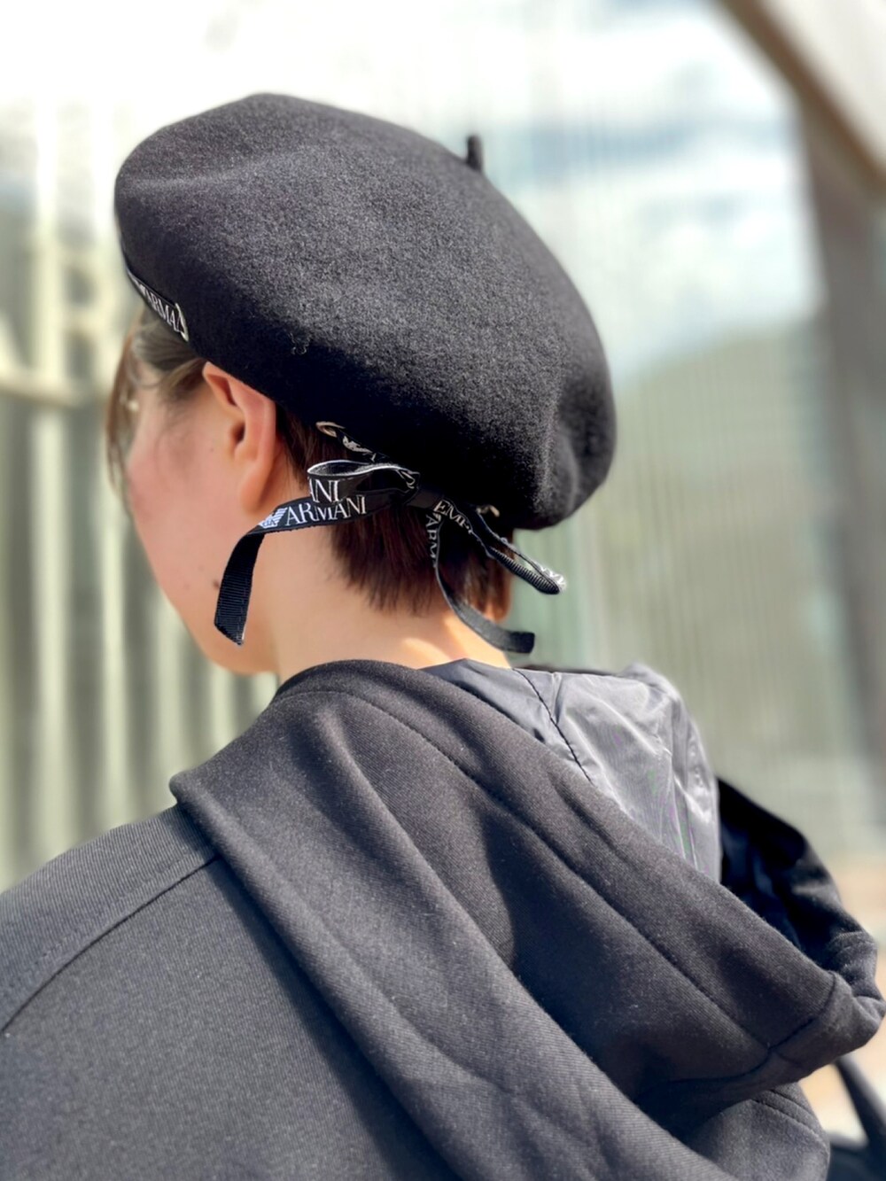 ブラック系のパーカー、ブラック系のスカート、ブラック系のスニーカーを着用したレディースの夏コーディネートの3枚目の写真