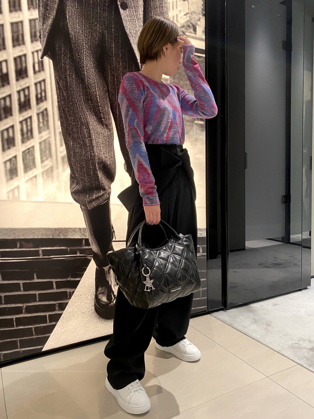 ピンク系のニット/セーター、ブラック系のパンツ、ブラック系のトートバッグを着用したレディースの秋コーディネートの2枚目の写真