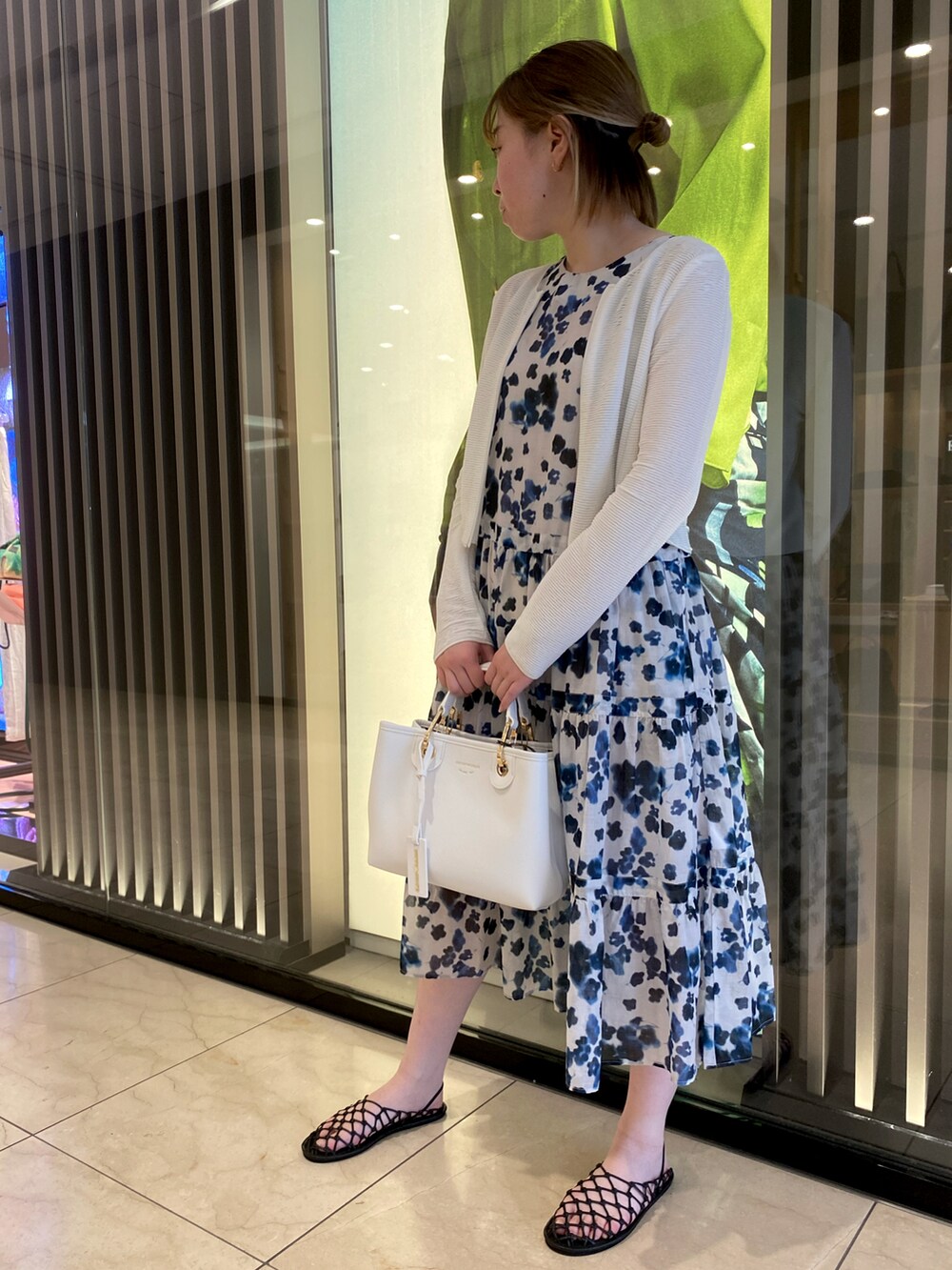 ホワイト系のカーディガン/ボレロ、ベージュ系のバッグ、ホワイト系のドレスを着用したレディースの春コーディネートの2枚目の写真