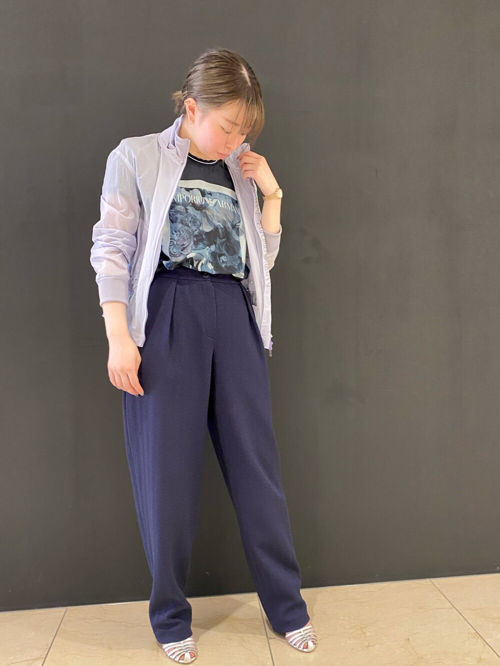 ブルー系のパンツ、ブルー系のハンドバッグ、シルバー系のパンプスを着用したレディースの春コーディネートの4枚目の写真