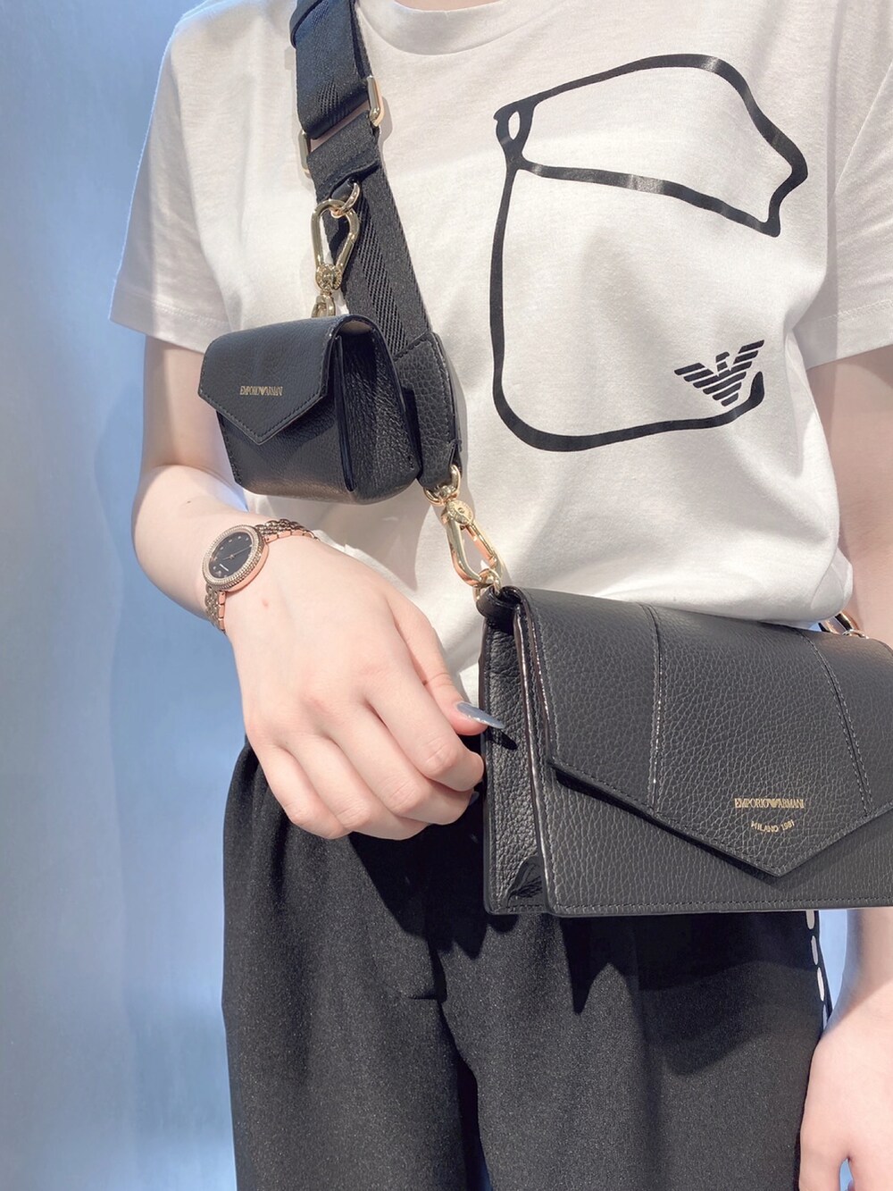 ホワイト系のTシャツ/カットソー、ブラック系のパンツ、ホワイト系のスニーカーを着用したレディースの夏コーディネートの2枚目の写真