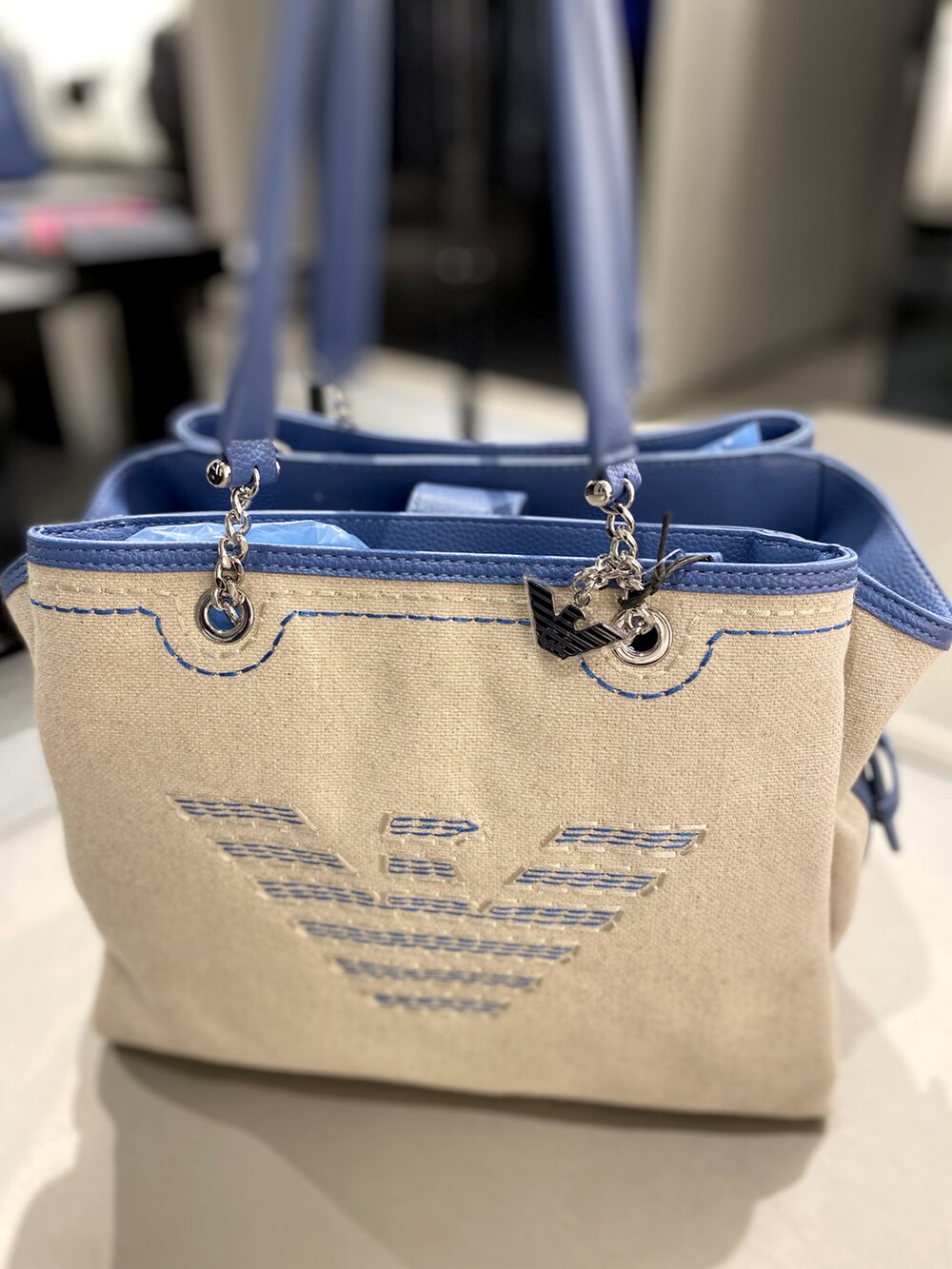 ブルー系のニット/セーター、ブルー系のスカート、ブルー系のハンドバッグを着用したレディースの春コーディネートの3枚目の写真