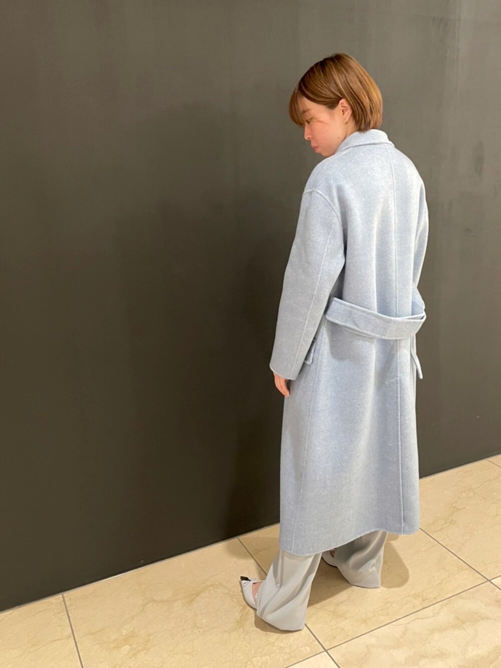 ブルー系のジャケット/アウター、ベージュ系のニット/セーター、グレー系のパンツを着用したレディースの秋コーディネートの2枚目の写真