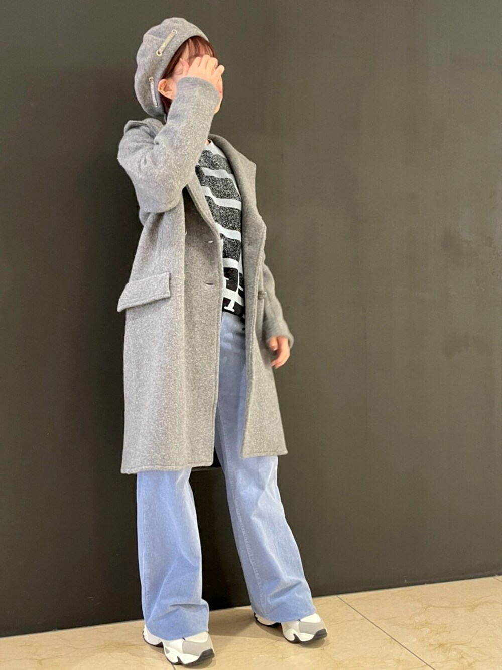 ブルー系のニット/セーター、グレー系のジャケット/アウター、ブルー系のパンツを着用したレディースの秋コーディネートの2枚目の写真