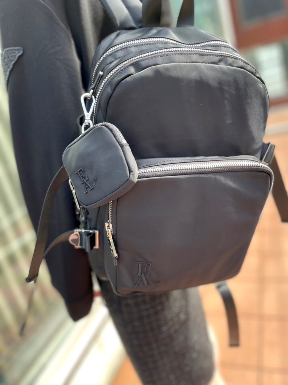 ブラック系のパーカー、ブラック系のスカート、ブラック系のスニーカーを着用したレディースの夏コーディネートの4枚目の写真